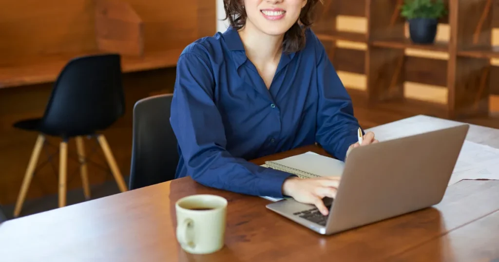 パソコンとノートを広げる女性